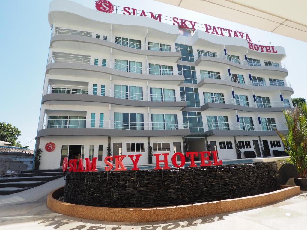 un grand bâtiment blanc avec une enseigne devant dans l'établissement Siam Sky Pattaya Hotel, 