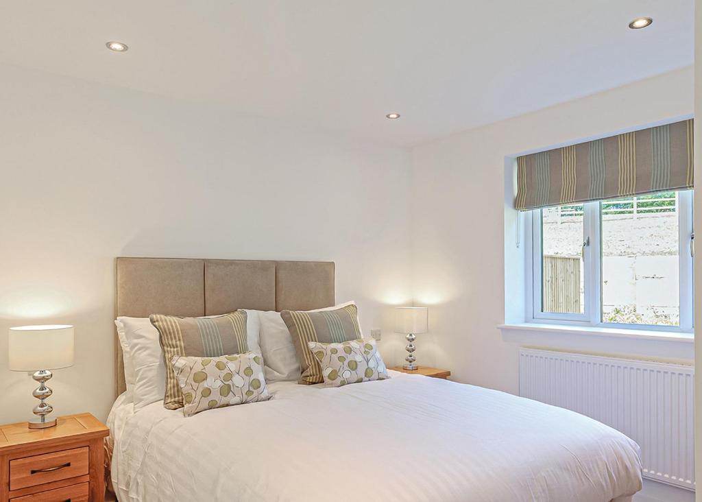 a bedroom with a large white bed and a window at Windmill Retreat in Middlezoy