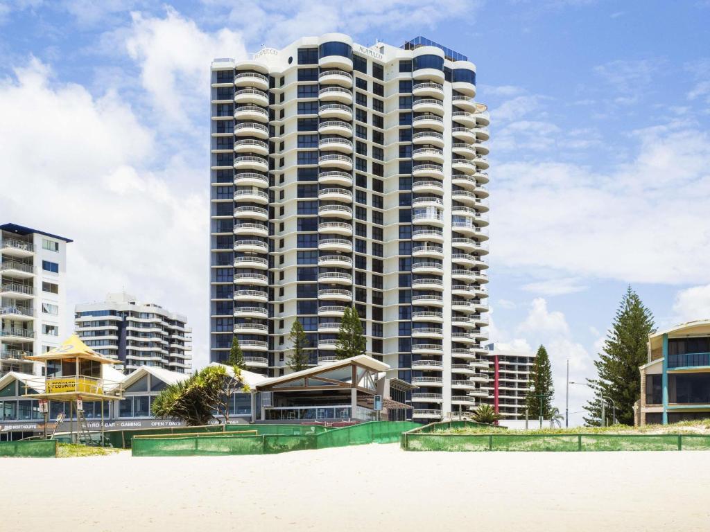 een hoog gebouw met een strand ervoor bij BreakFree Acapulco in Gold Coast
