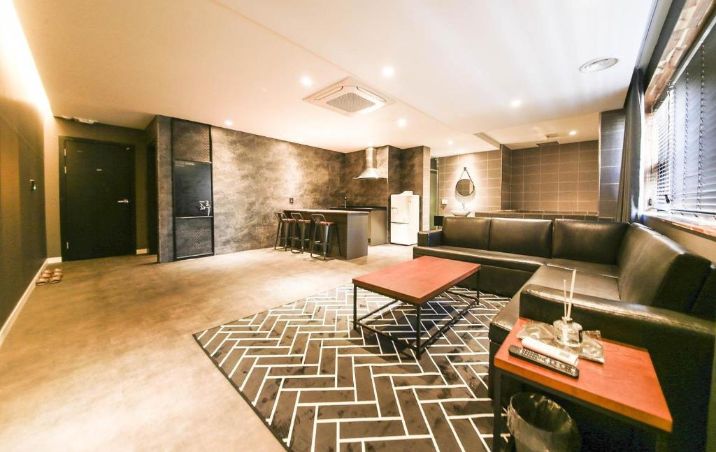 een woonkamer met een bank en een tafel bij 천안 호텔 하루 in Tujŏng-dong