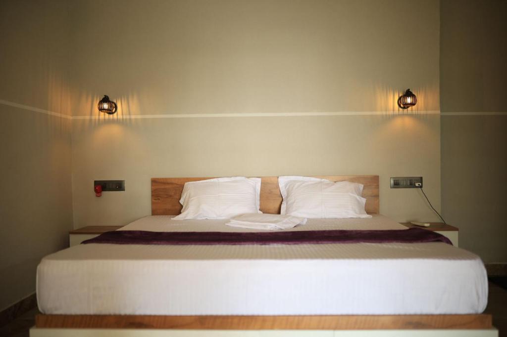 a bedroom with a large bed with white pillows at Kghomestay in Pallipuram