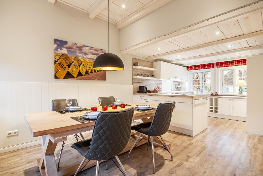 a kitchen and dining room with a wooden table and chairs at FöhrEuch 2 in Borgsum
