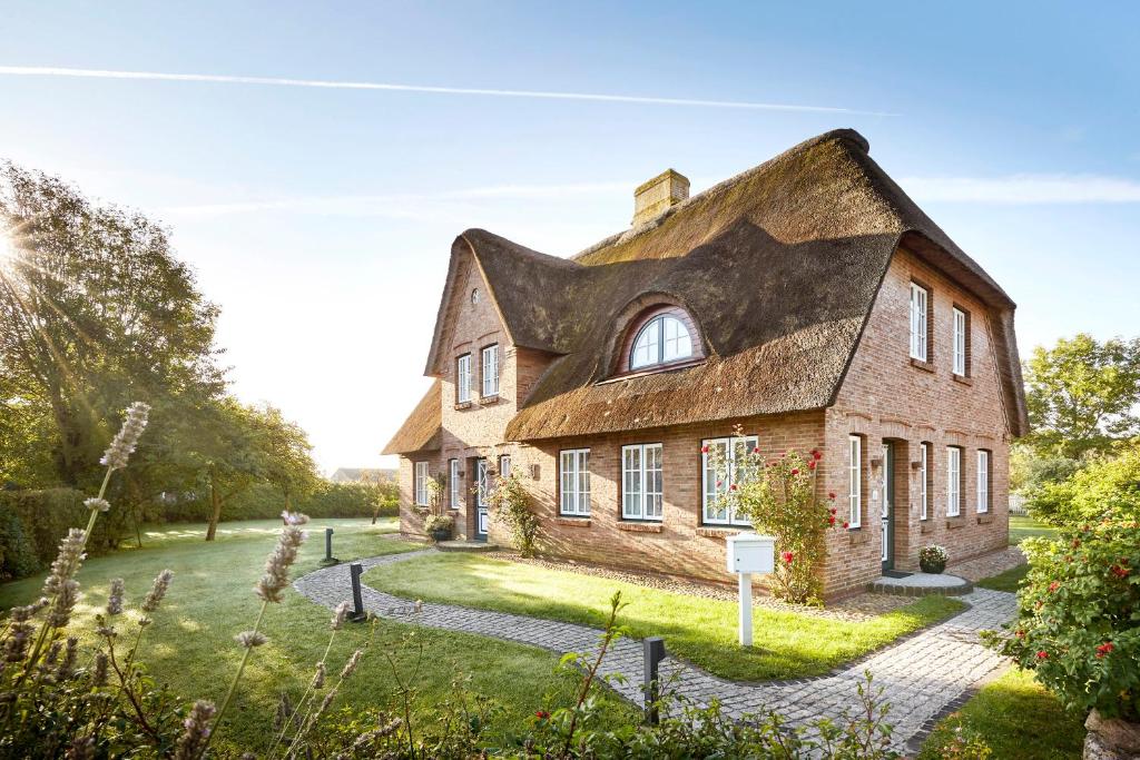 een oud stenen huis met een dakraam bij Reethüs Marta - rechts in Utersum