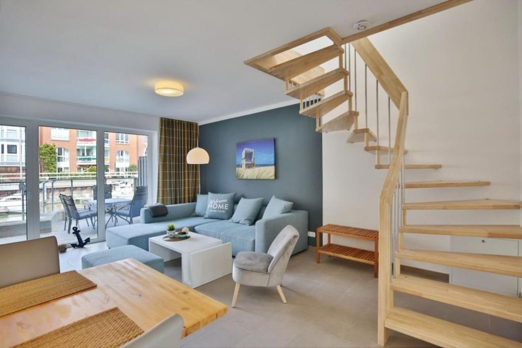 a living room with a blue couch and stairs at City Marina, CM20a in Cuxhaven