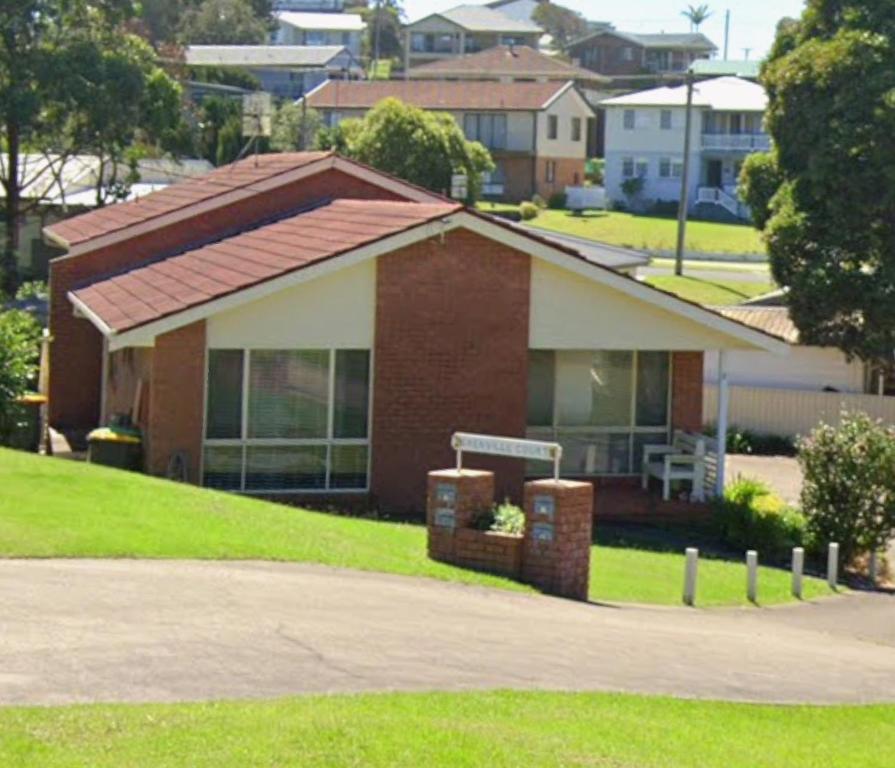 a house with a red roof and a driveway at The little beach house in Tuross Heads