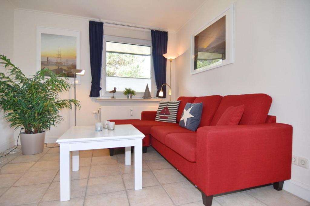a living room with a red couch and a white table at Luv & Lee, Whg 3 in Westerland