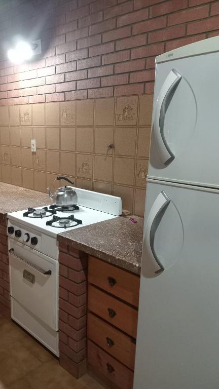a kitchen with a stove and a white refrigerator at Departamento en barrio tranquilo in Mar del Plata