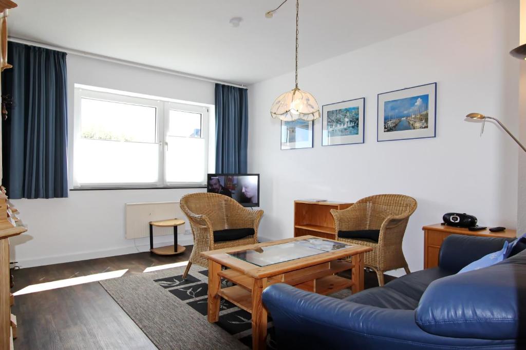 een woonkamer met een blauwe bank en een tafel bij Strandmuschel in Hörnum