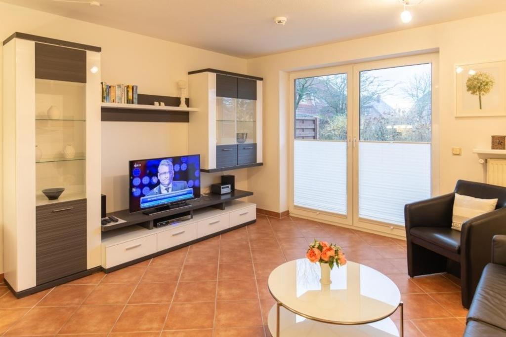 a living room with a television and a table at Stranddüne, D13 in Duhnen