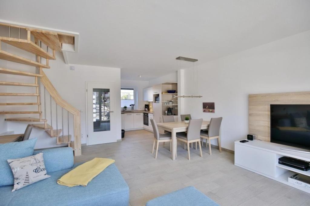 a living room with a blue couch and a table at City Marina, CM24d in Cuxhaven
