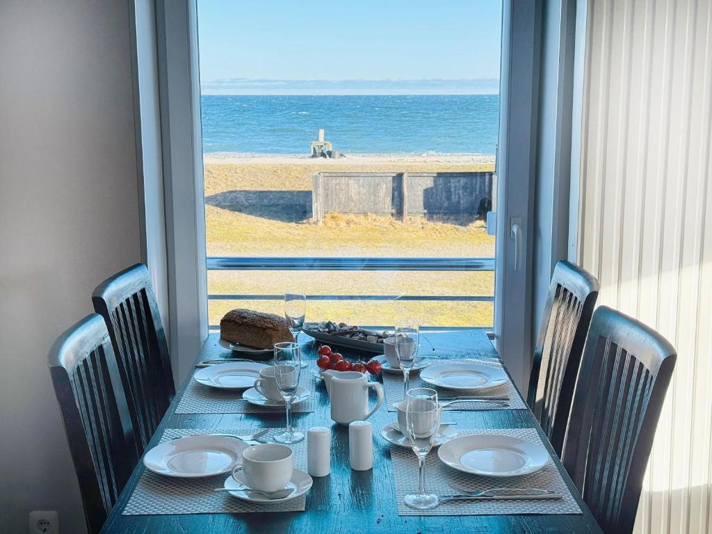 a blue table with a view of the beach at Apartment Priwall Teichhof Fehmarn in Wenkendorf