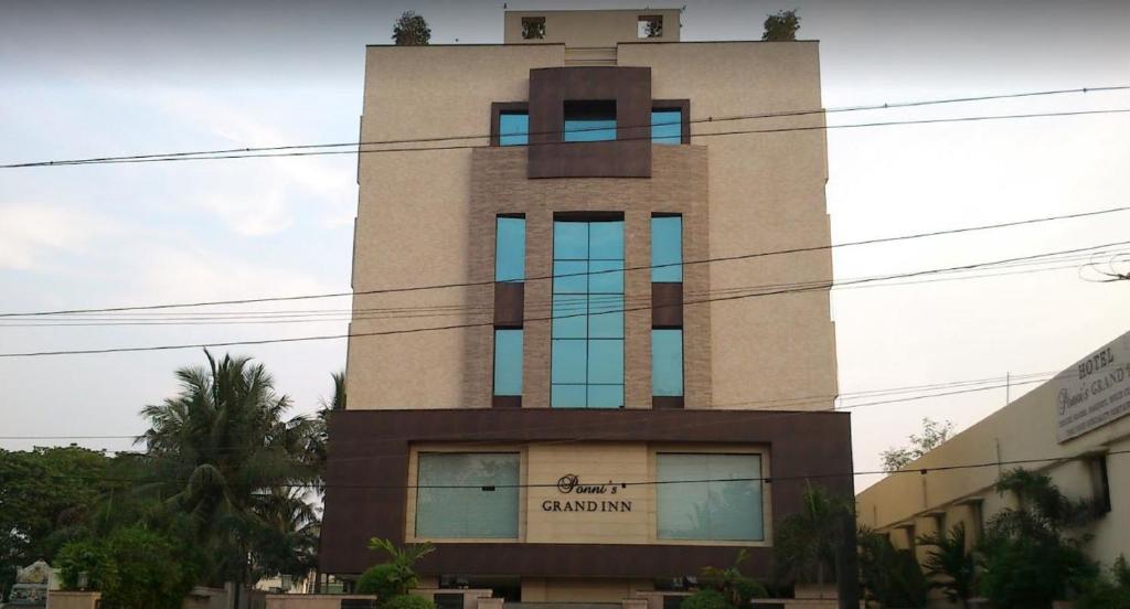 ein hohes Gebäude mit blauen Fenstern darauf in der Unterkunft Ponnis Grand Inn in Chennai