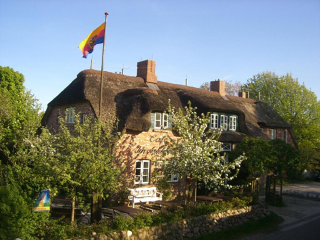 an old house with a flag on top of it at Im Apfelgarten in Oldsum