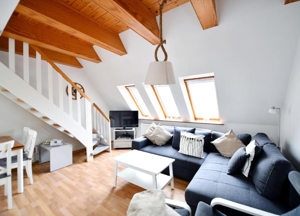 a living room with a blue couch and some windows at Südstranddomizil 56 in Wyk auf Föhr
