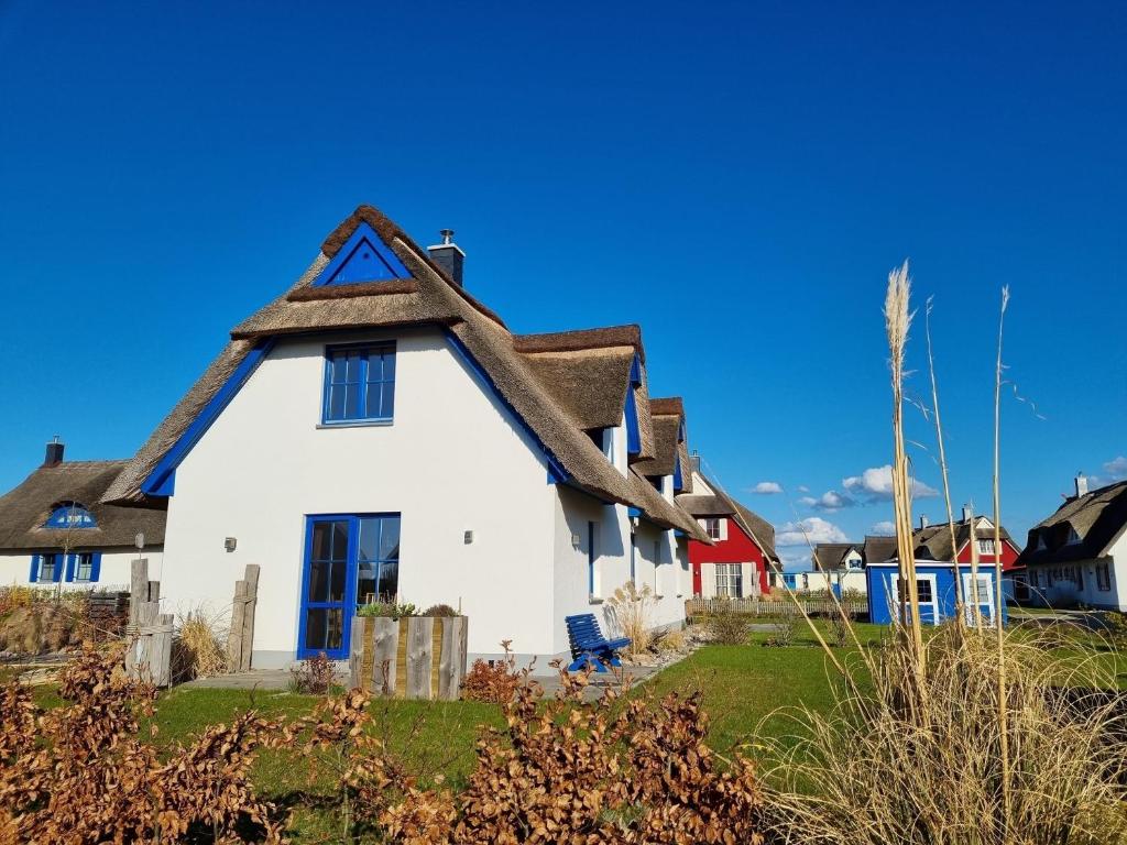 a white house with a thatched roof at Reethaus "Melsa" in Zierow
