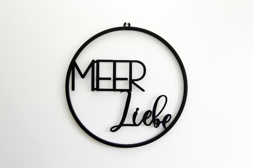 a black and white circle sign with the words her life at Meer-Liebe in Hörnum