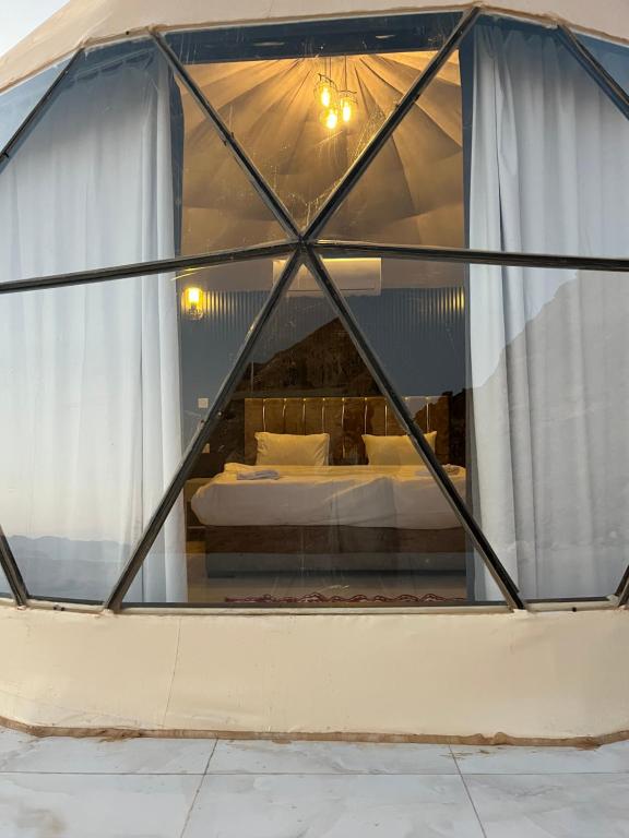 a room with a bed inside of a tent at Madonna Rum camp bubbles & Jeep tours in Wadi Rum