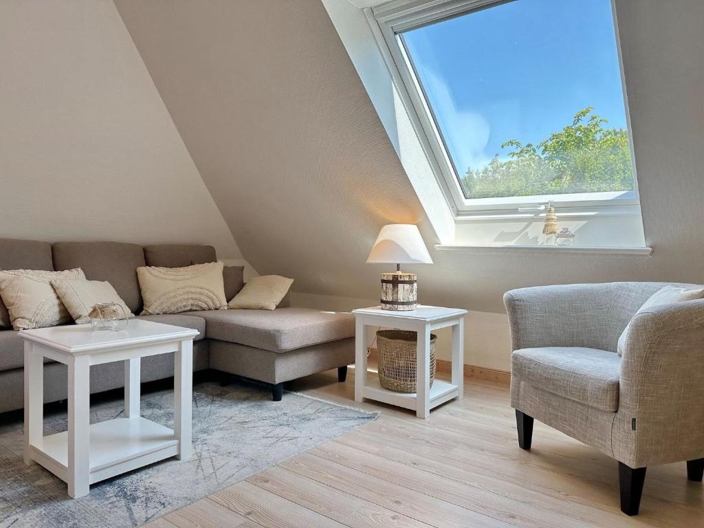 a living room with a couch and a window at Sinfonie, Whg 5 in Tinnum