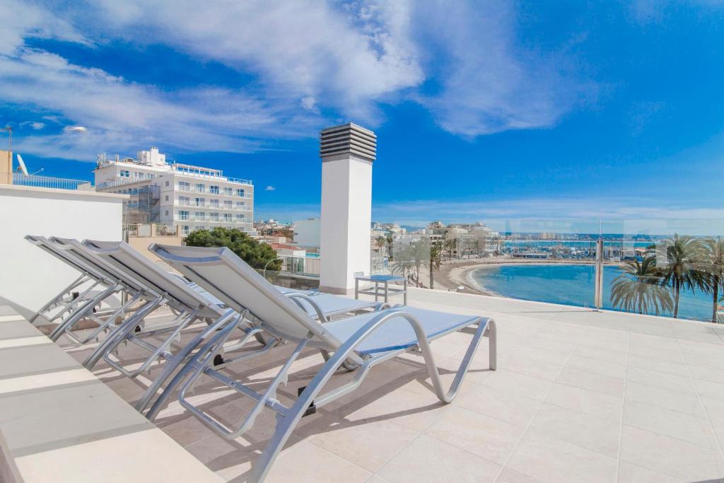 une paire de chaises longues sur le toit d'un bâtiment dans l'établissement Apartments Beach 4U - Can Pastilla, à Can Pastilla