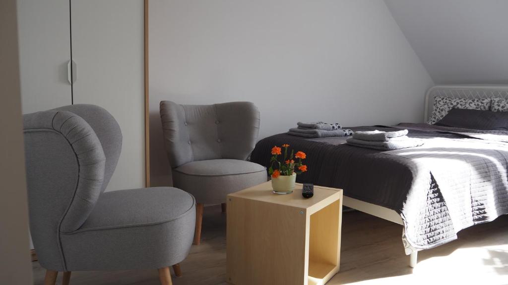 1 dormitorio con 2 sillas, 1 cama y 1 mesa en Wendy's Apartment en Gdansk