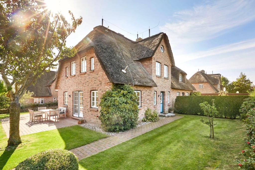 una grande casa in mattoni con tetto di paglia di Haus Traumstraße a Hedehusum