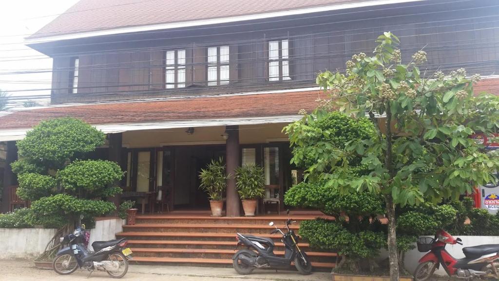 een huis met motoren die er voor geparkeerd staan bij Bualuang Hotel in Luang Prabang