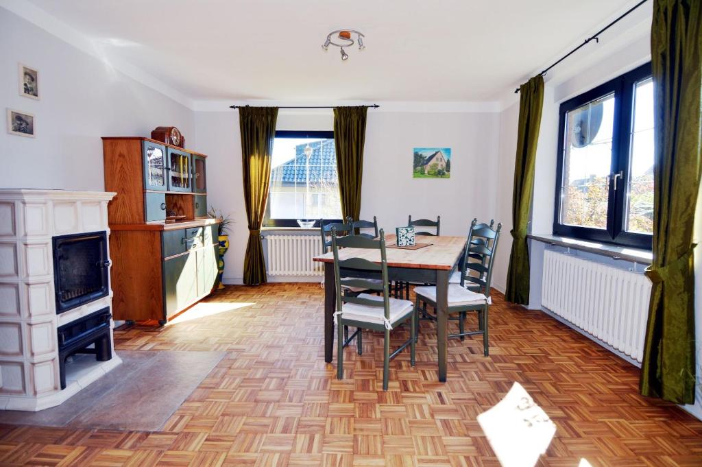 a dining room with a table and chairs and a fireplace at Breslauer Haus in Heiligenhafen