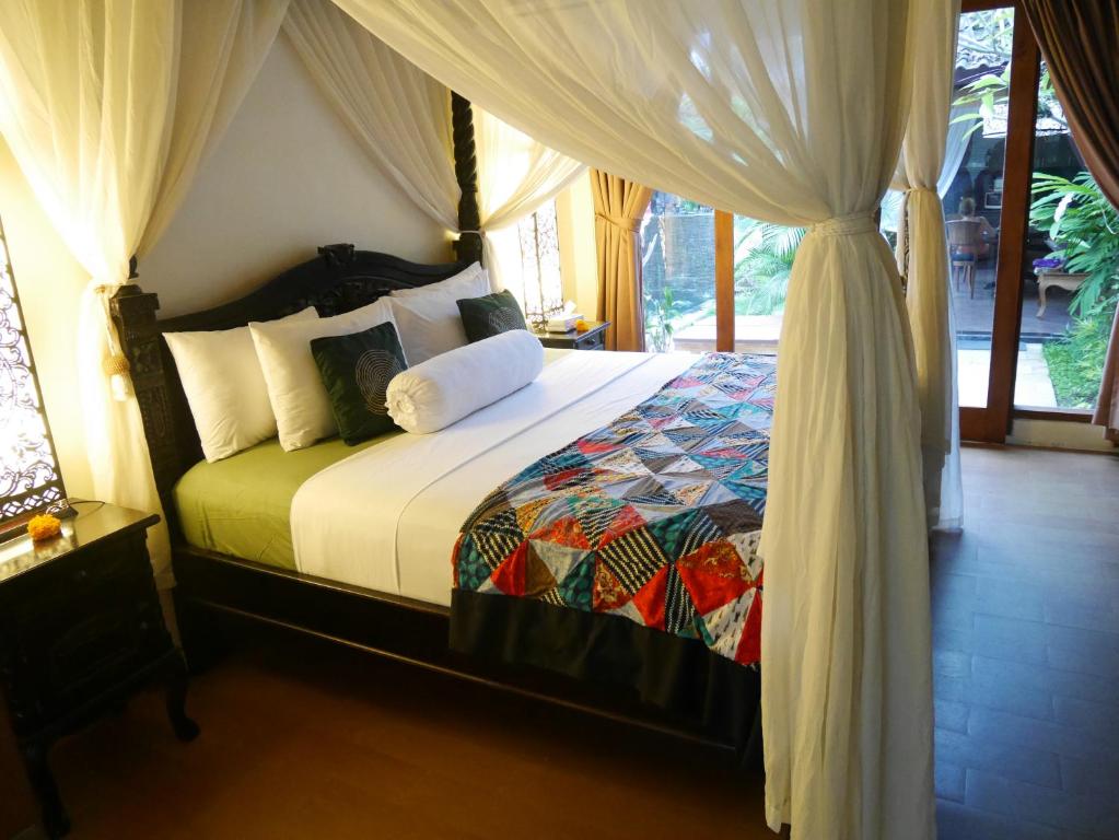 a bedroom with a bed with a canopy at Pondok Penestanan Villa Ubud in Ubud
