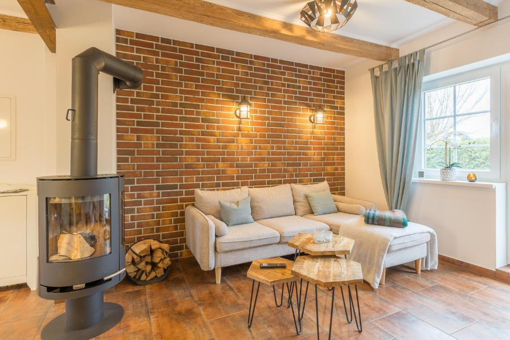 a living room with a couch and a brick wall at Ferienwohnung Ina Meta in Reppenhagen