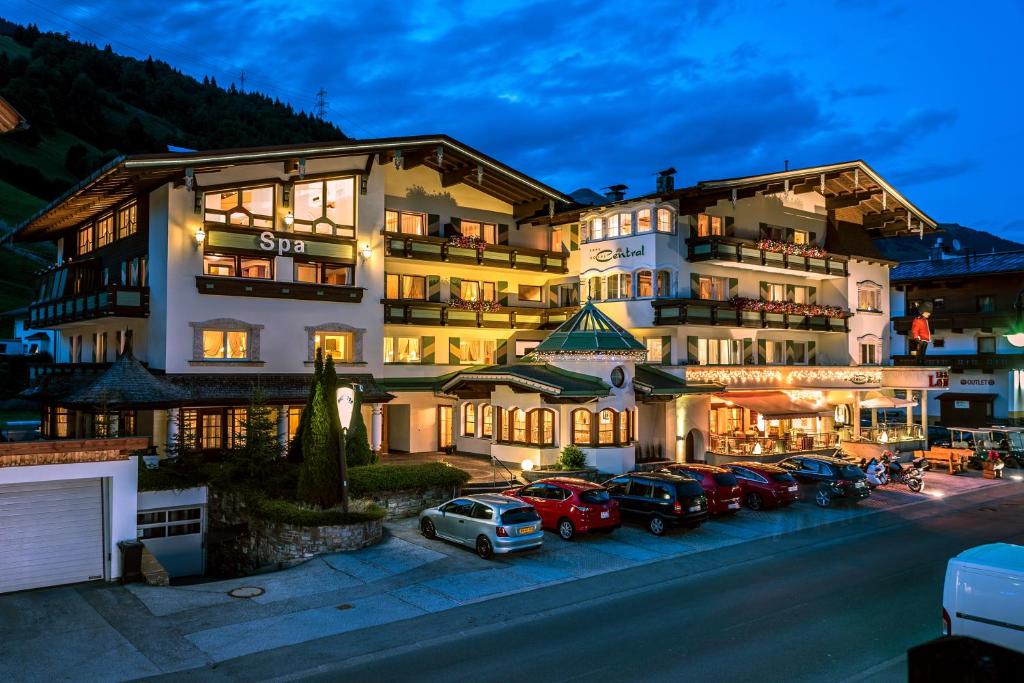 a hotel with cars parked in a parking lot at Hotel Central in Gerlos