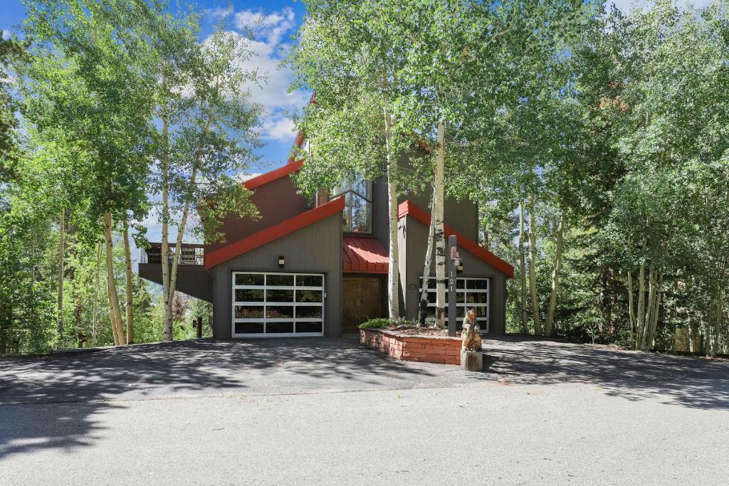 a house in the trees with a driveway at Bear Peak Lodge 1 Mile to Gondola and Great Views in Breckenridge
