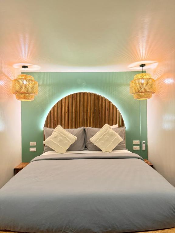 een slaapkamer met een groot bed met twee lampen erboven bij Lugadia Villas in El Nido