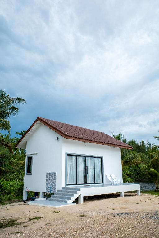 a white house with a bench in front of it at The Rock Coco Villa 2 in Ban Sai Mat