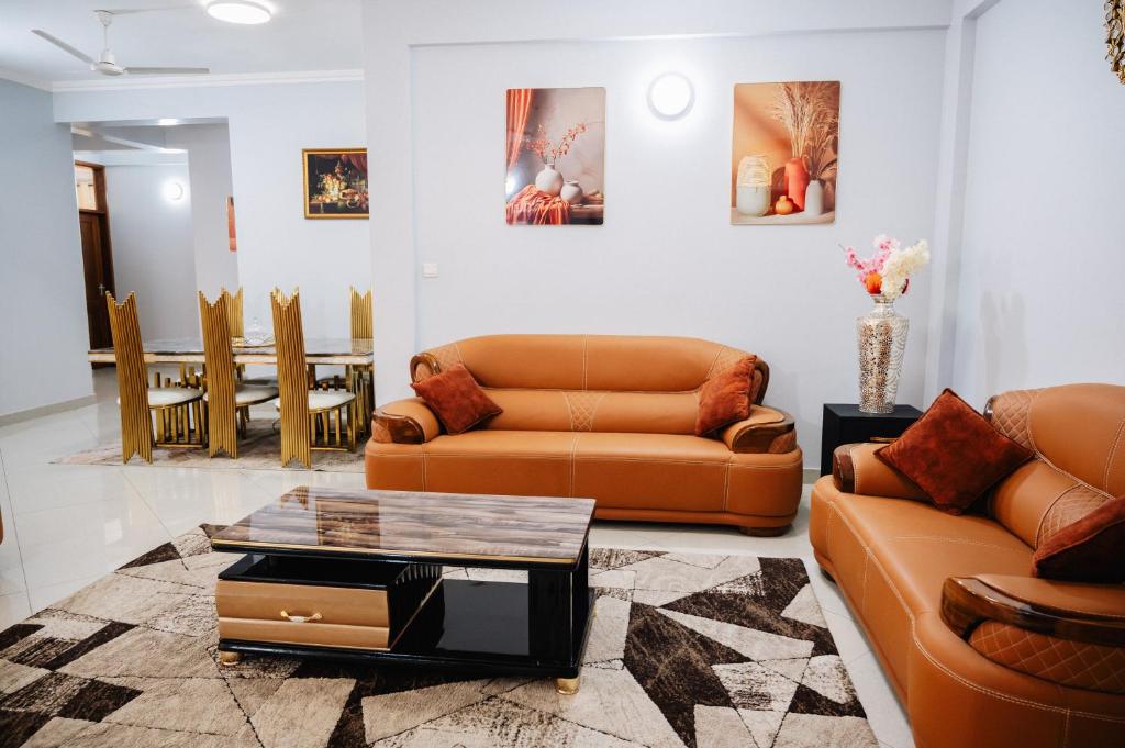 a living room with two couches and a table at Abnaa Apartment in Zanzibar City