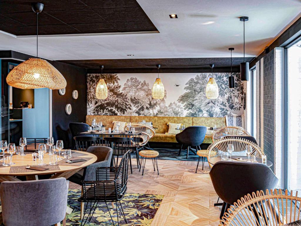 een restaurant met tafels en stoelen in een kamer bij Novotel Lens Noyelles in Noyelles-Godault