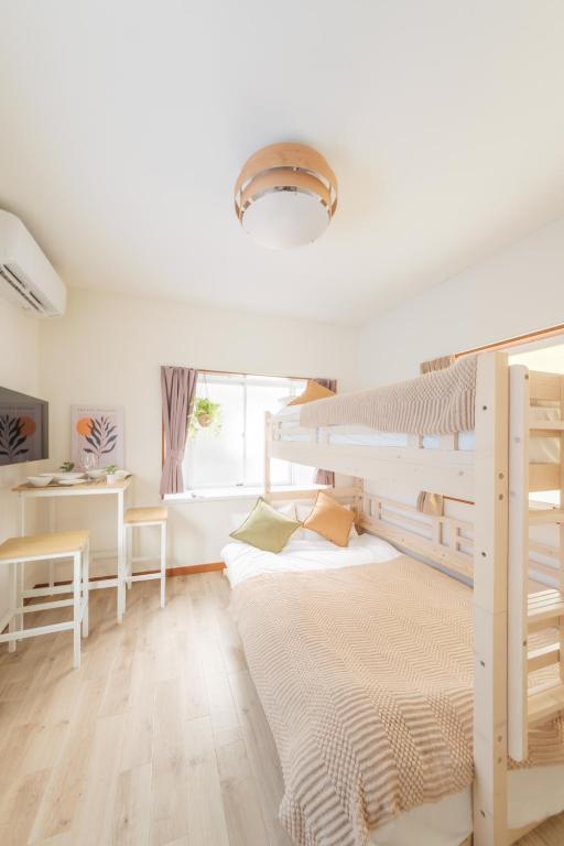 a bedroom with a bunk bed and a desk at Hotel Emile102 in Tachikawa