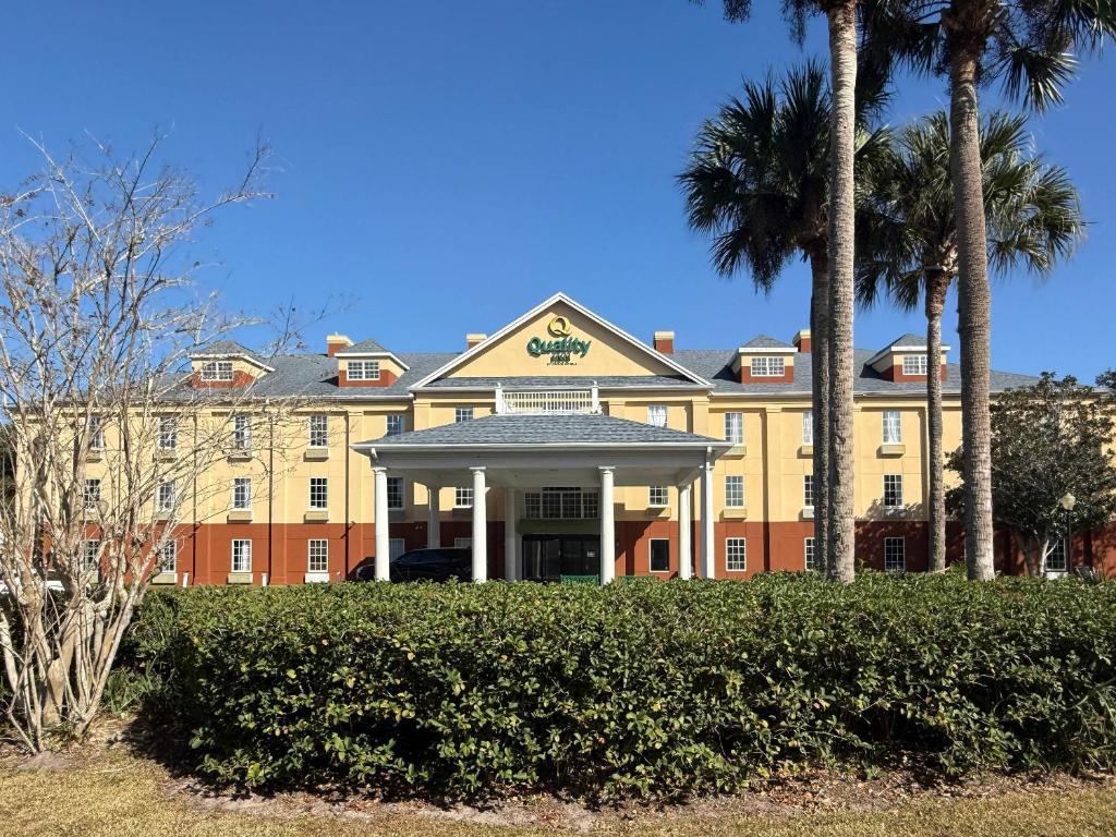 ein großes Gebäude mit Palmen davor in der Unterkunft Quality Inn Ormond Beach - Daytona in Ormond Beach