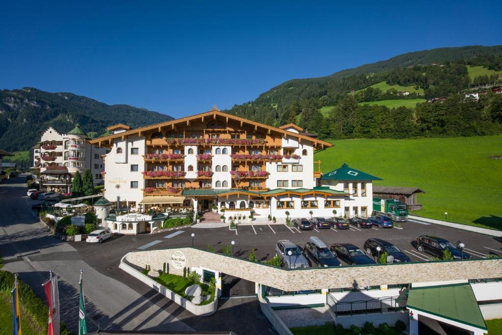 a large building with cars parked in a parking lot at Hotel Neue Post in Hippach