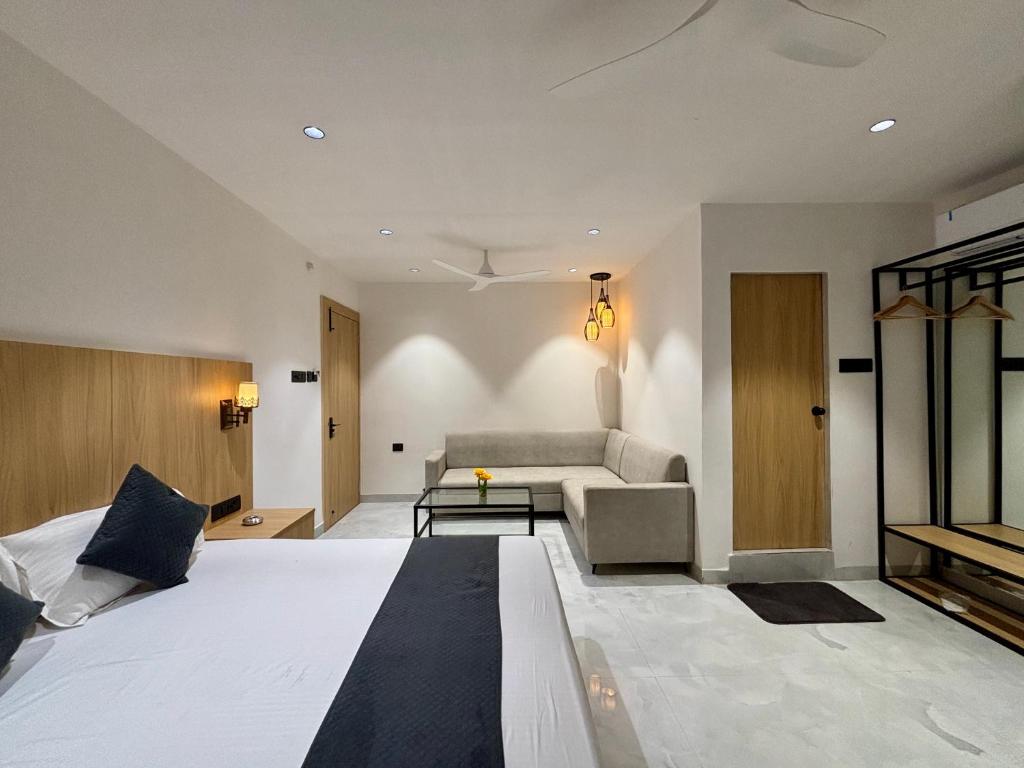 a bedroom with a large bed and a couch at The Hyde Park Inn in Bilāspur