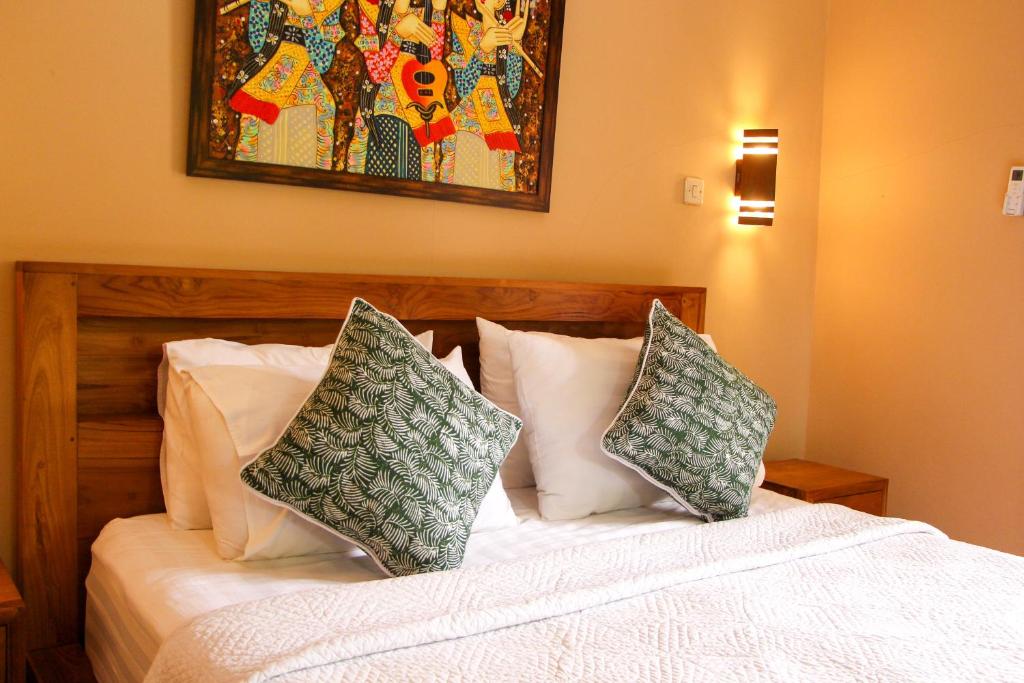 een slaapkamer met een bed met twee kussens erop bij Ananda House in Ubud