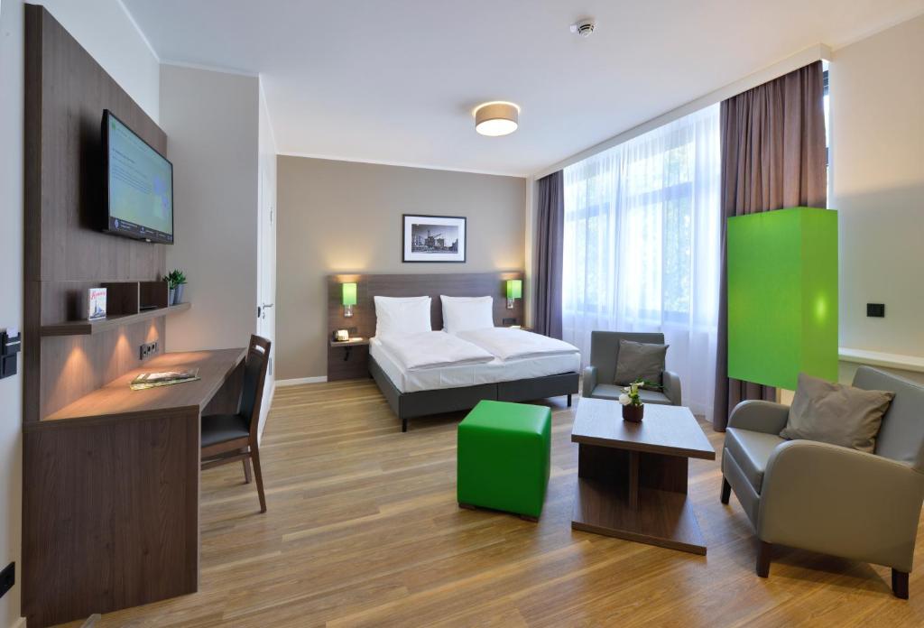 a hotel room with a bed and a desk at Appartello Smarttime living Hamburg in Hamburg