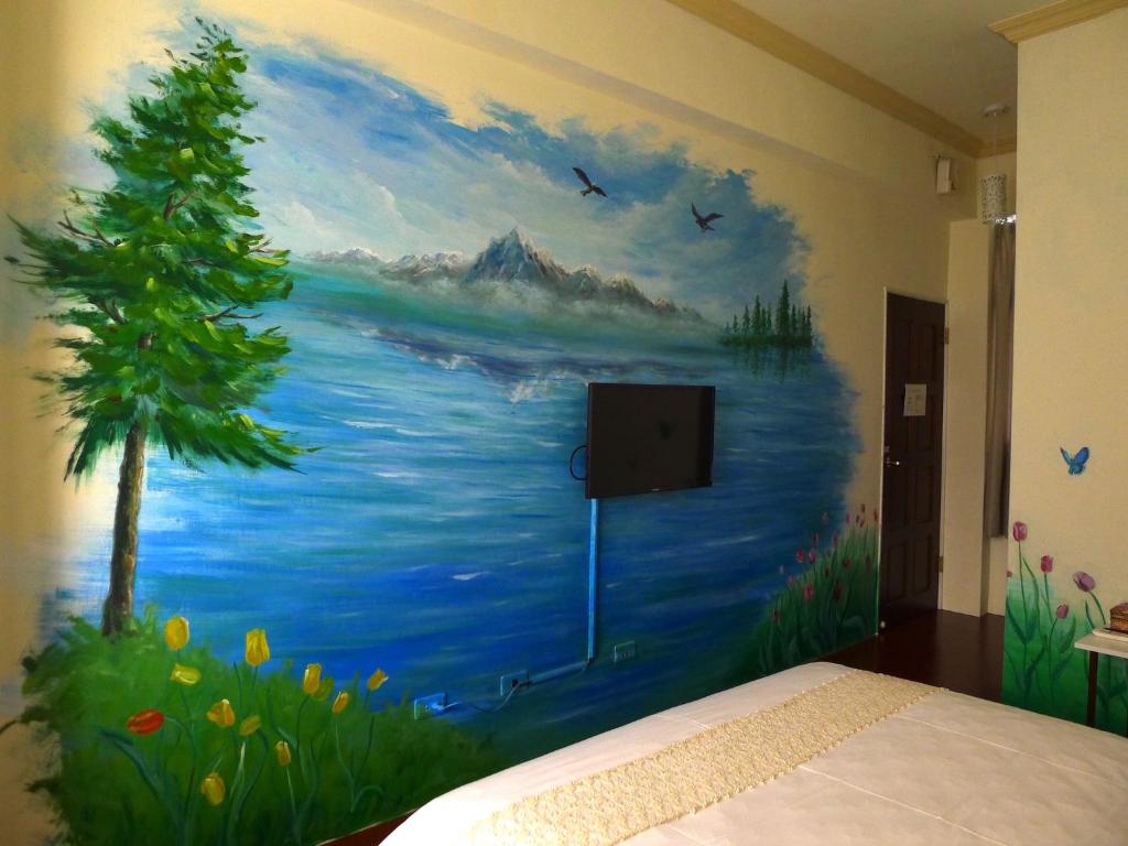 a bedroom with a painting on the wall at Amicasa Guesthouse in Hualien City