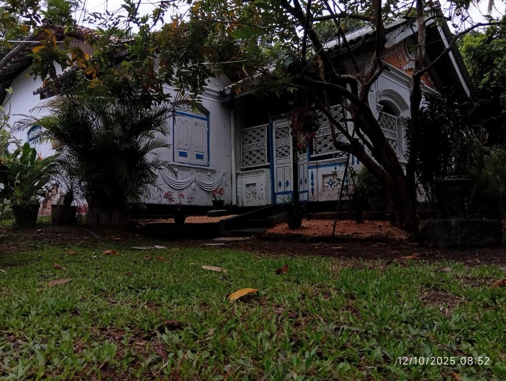 a house with blue and white doors and a yard at Grandma's House Villa in Weligama