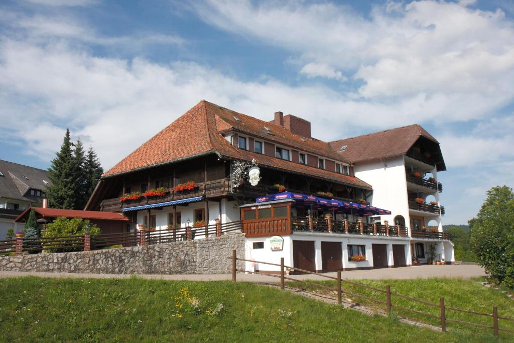 ein großes Gebäude mit Tischen und Stühlen davor in der Unterkunft Parkhotel Waldlust in Häusern