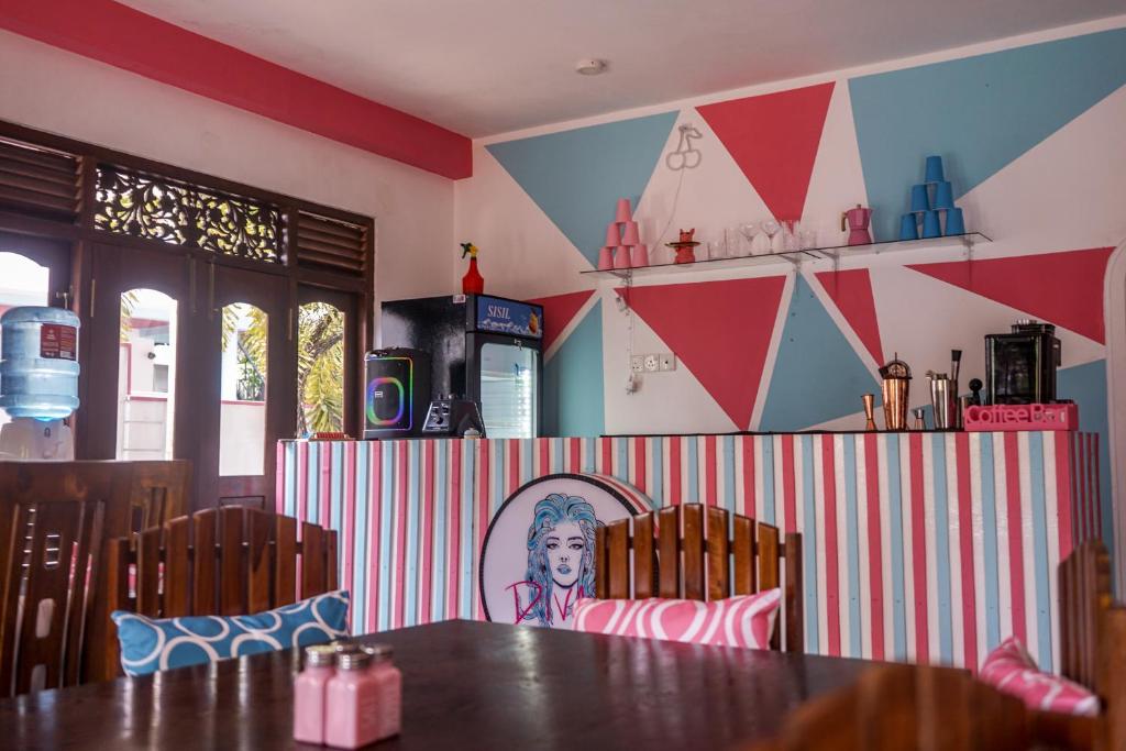 a dining room with a table and a colorful wall at Divas Hostels in Ahangama