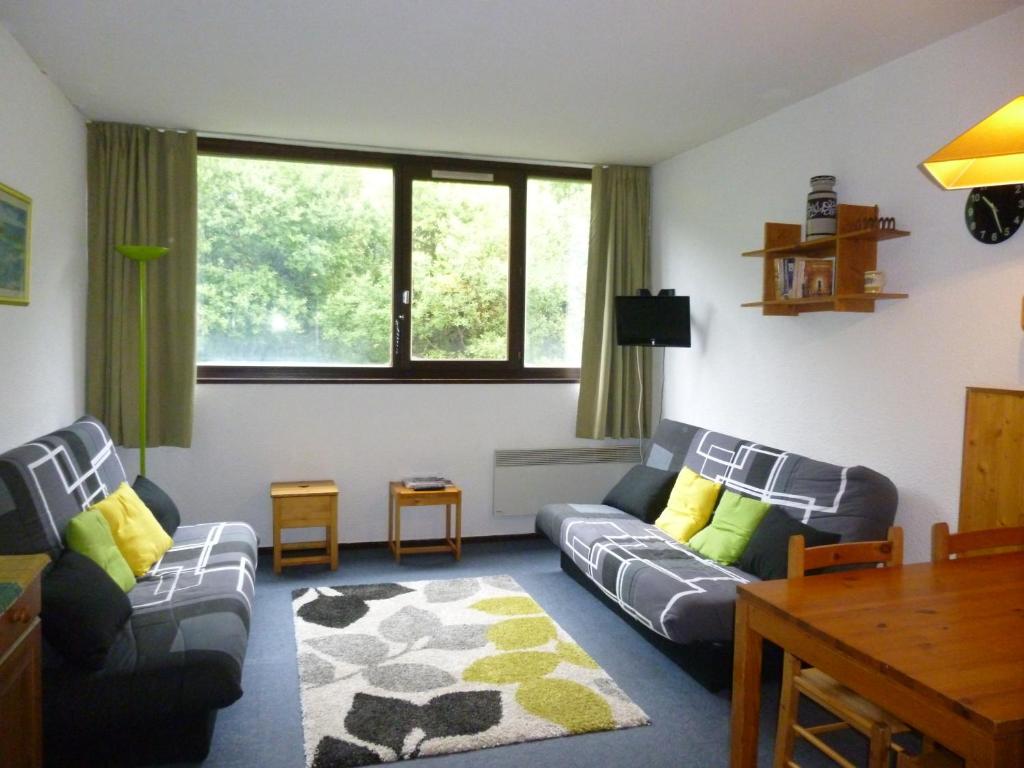 ein Wohnzimmer mit 2 Sofas und einem Tisch in der Unterkunft Appartement Flaine Forêt in Flaine