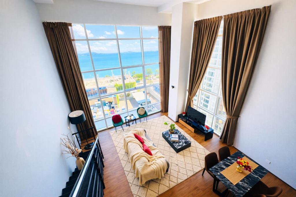 een woonkamer met een groot raam bij Modern Seaview 2BR Duplex High Floor Heart of George Town 73A in George Town
