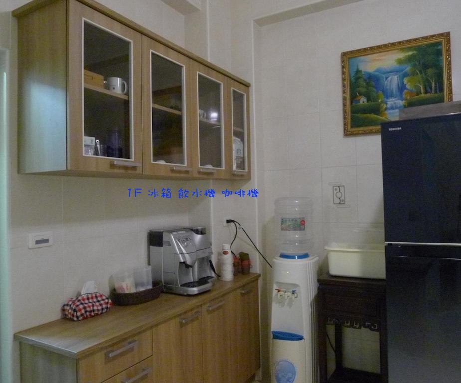 a kitchen with a counter with a microwave and a refrigerator at Amicasa Guesthouse in Hualien City