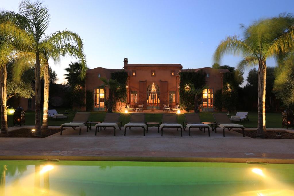 a house with palm trees and a swimming pool at Villa Jannah in Marrakech