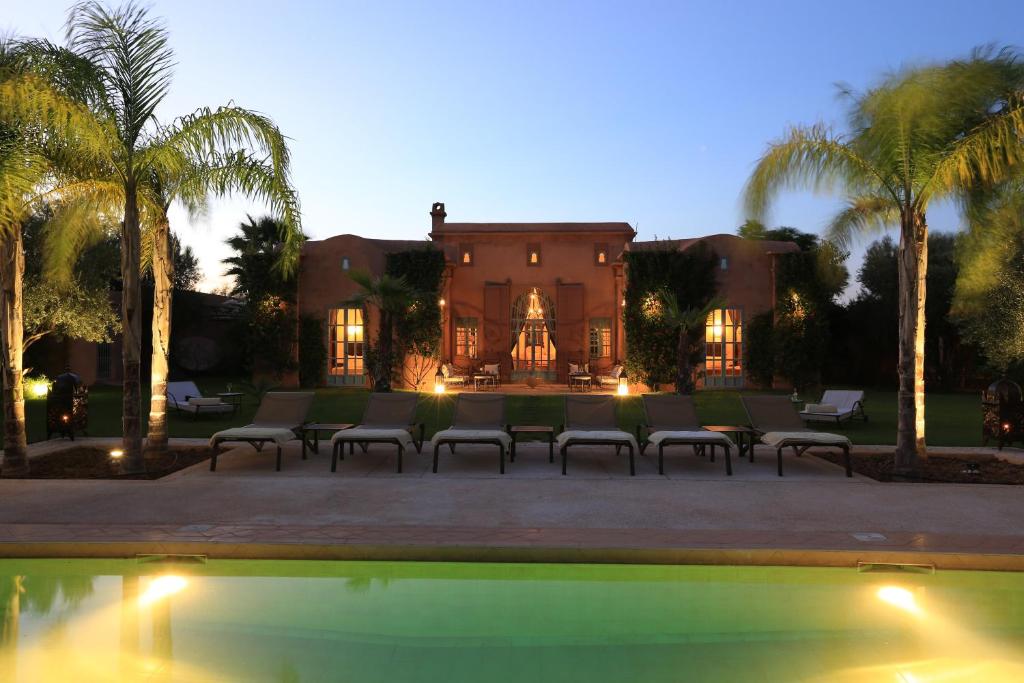 a house with palm trees and a swimming pool at Villa Jannah in Marrakesh